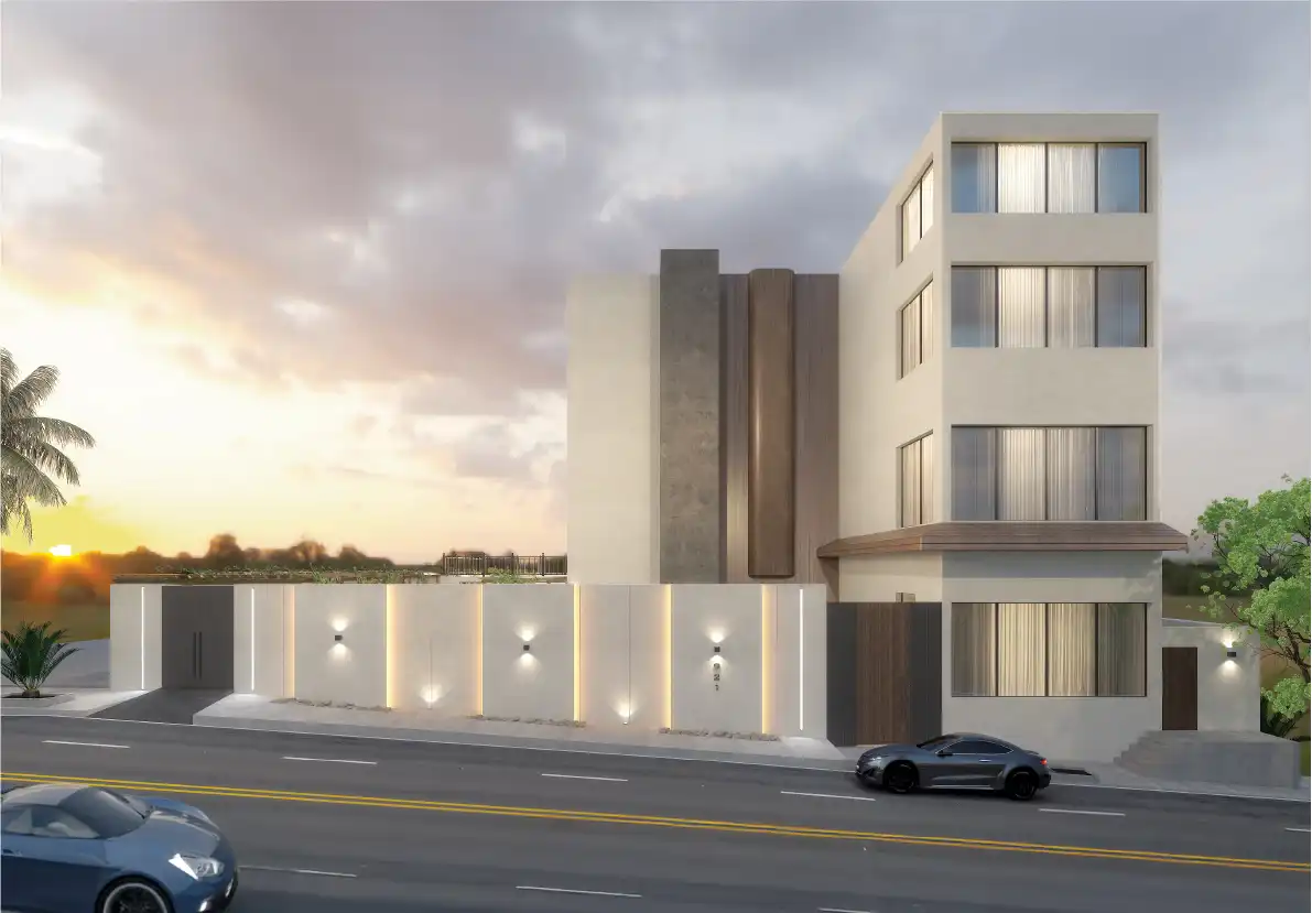 Cream-rendered building at sunset behind a long white boundary wall lit by recessed vertical light strips, up-and-down wall lights and ground uplights, with a dark timber gate and cars on the road