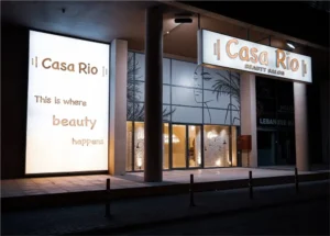 Casa Rio Beauty Salon shopfront at night in JVC, Dubai, with the lit signage and window graphic