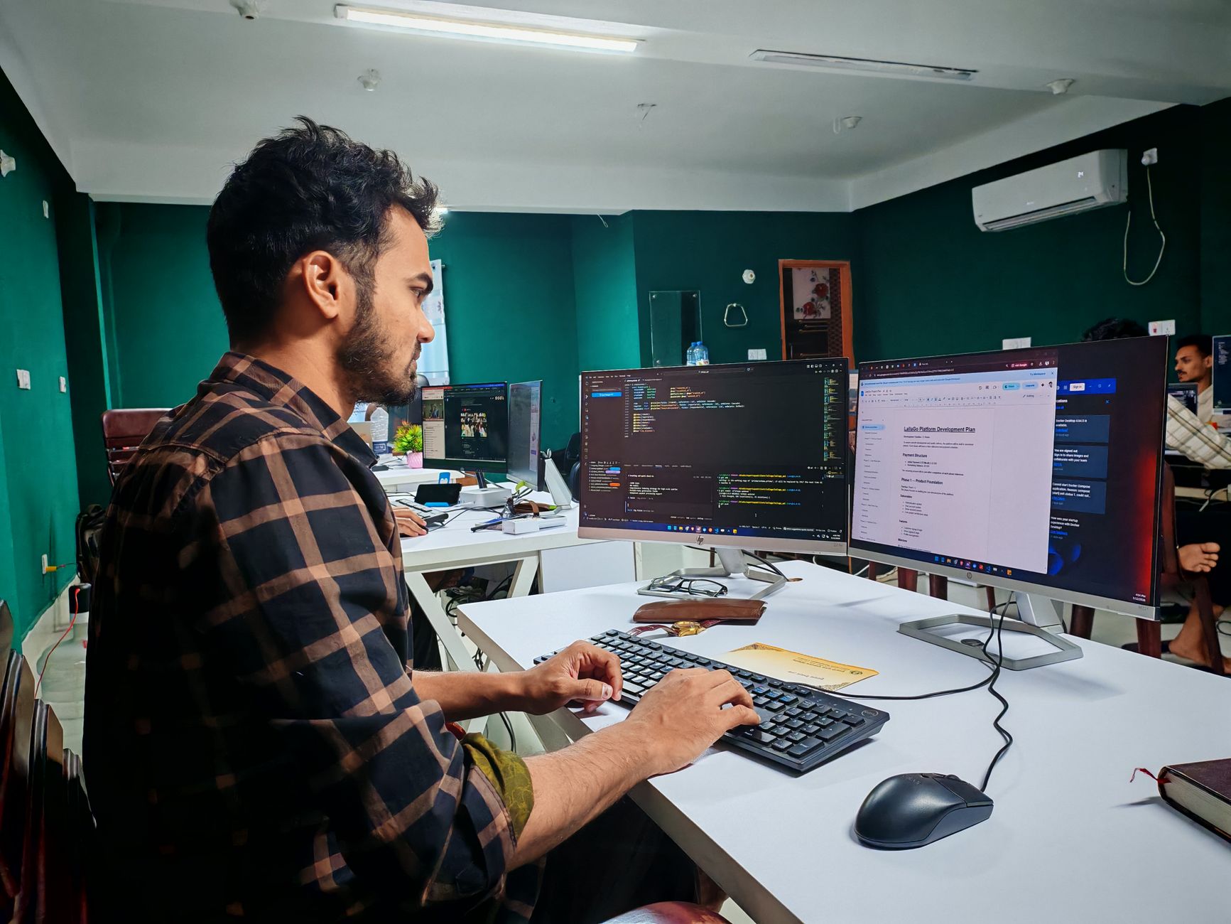 Developers writing code for a website build on dual monitors