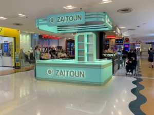 Zaitoun, Kuala Lumpur: One Food Brand, Six Retail Formats and a Built Kiosk in Sunway Pyramid | Kenania Inventive Arts Zaitoun kiosk built in Sunway Pyramid, Kuala Lumpur: mint-green counter with illuminated canopy sign